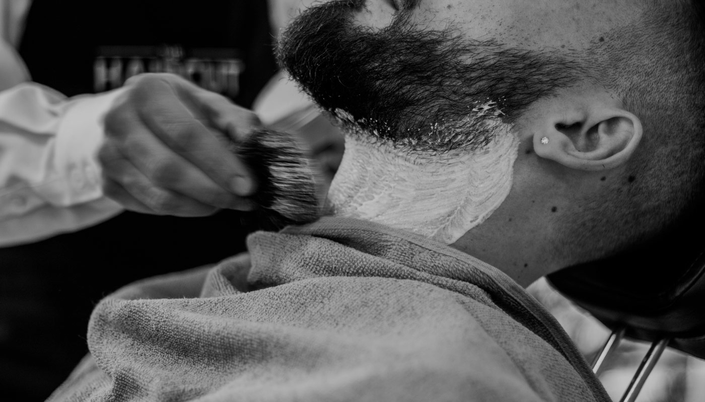 Shaving brush applying lather to a client's neck
